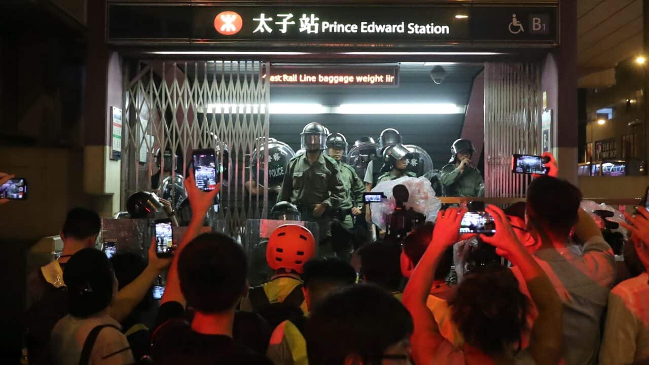 Police officers stand at the entrance to a subway station in Hong Kong.