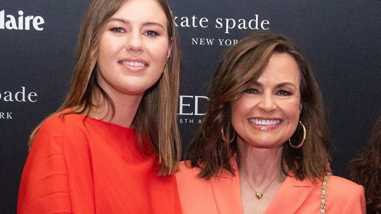 Women smile while posing for a photo.