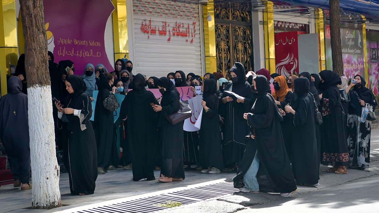 Around 20-30 Afghan women gather outside a beauty salon to stage a protest