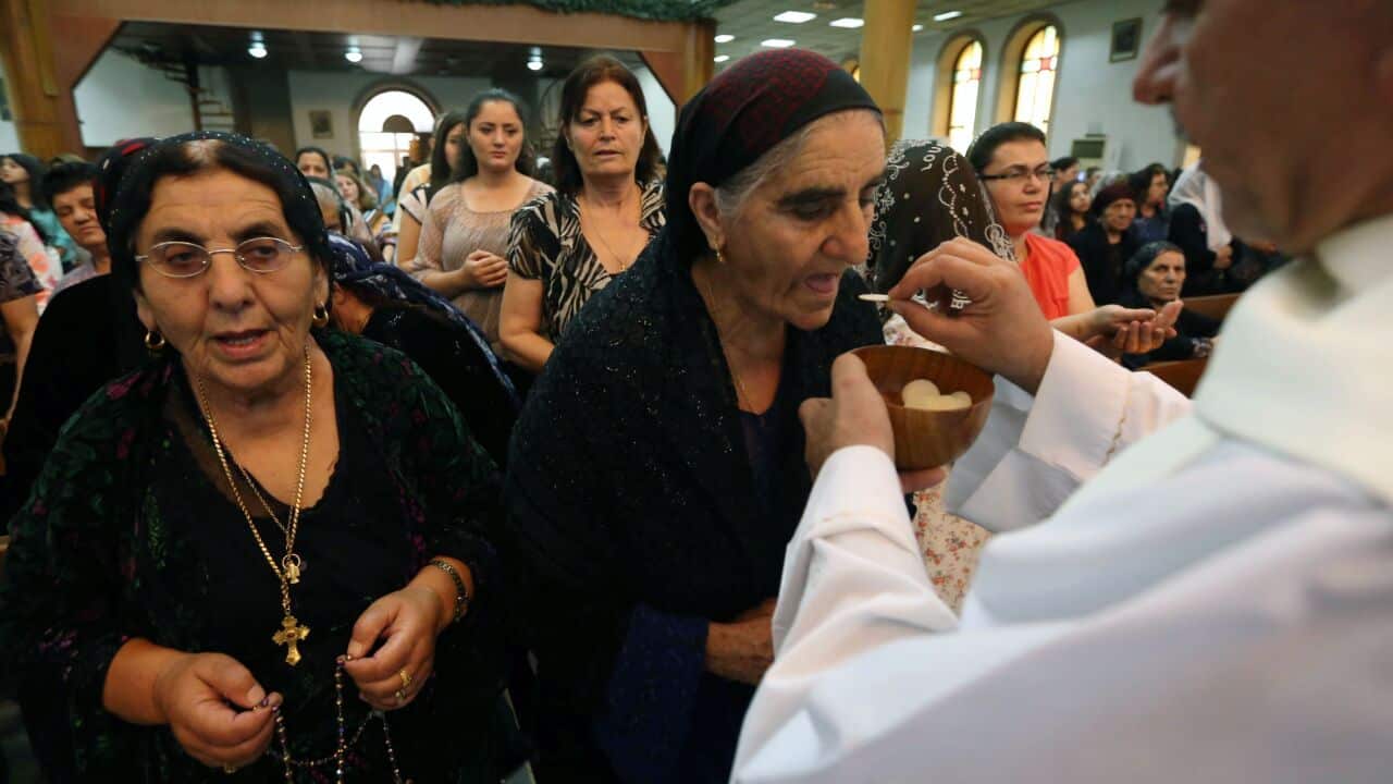 Iraqi Christians receive communion during a mass at the Saint-Joseph church in Arbil, the capital of the autonomous Kurdish region of northern Iraq, on July 20, 2014. Hundreds of Christian families fled their homes in Mosul on July 20, 2014 as a jihadist