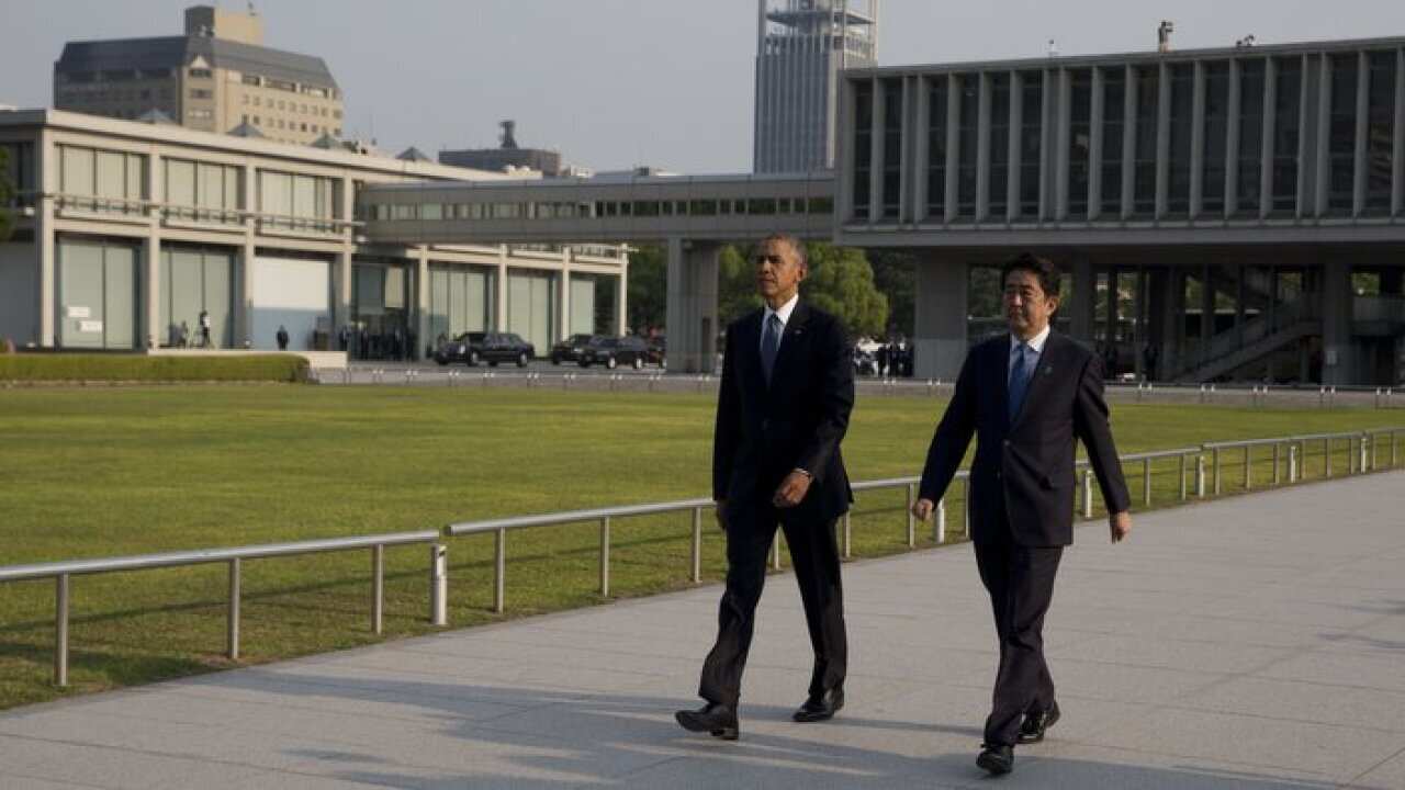 Barack Obama and Shinzo Abe walk to a ceremony at Hiroshima Peace Memorial Park in Hiroshima