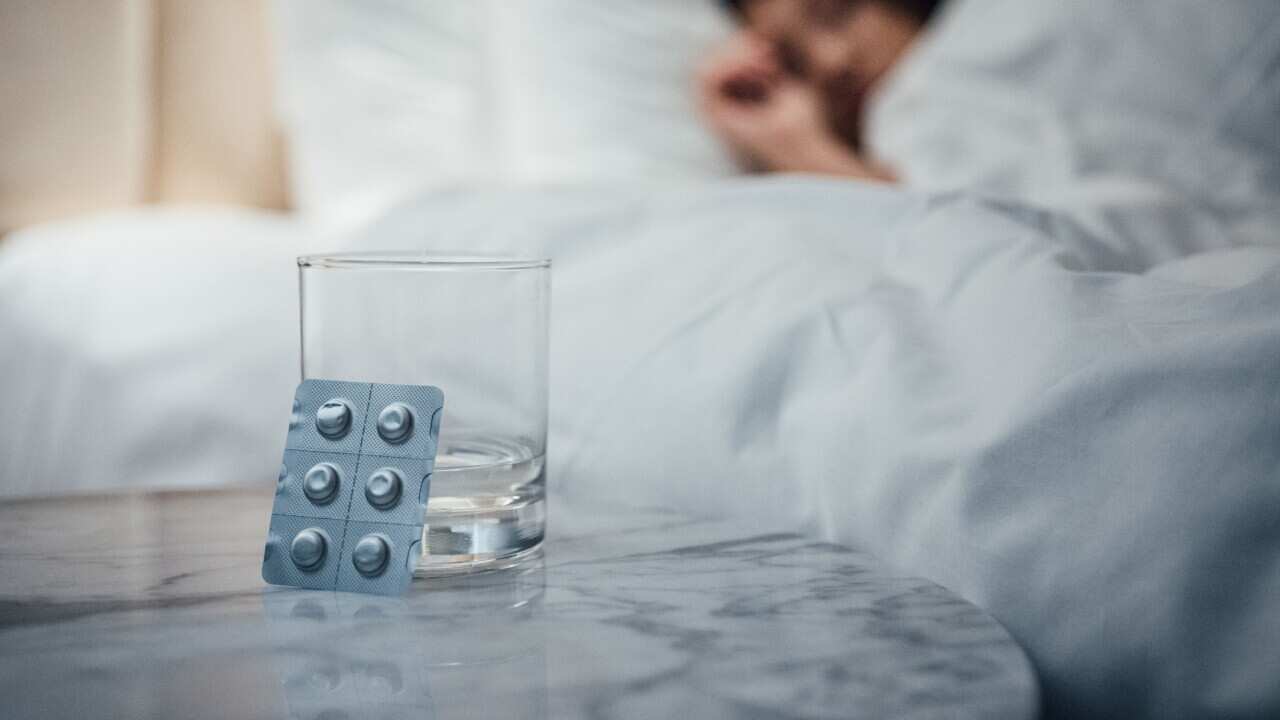 Close up shot of pills and a glass of water