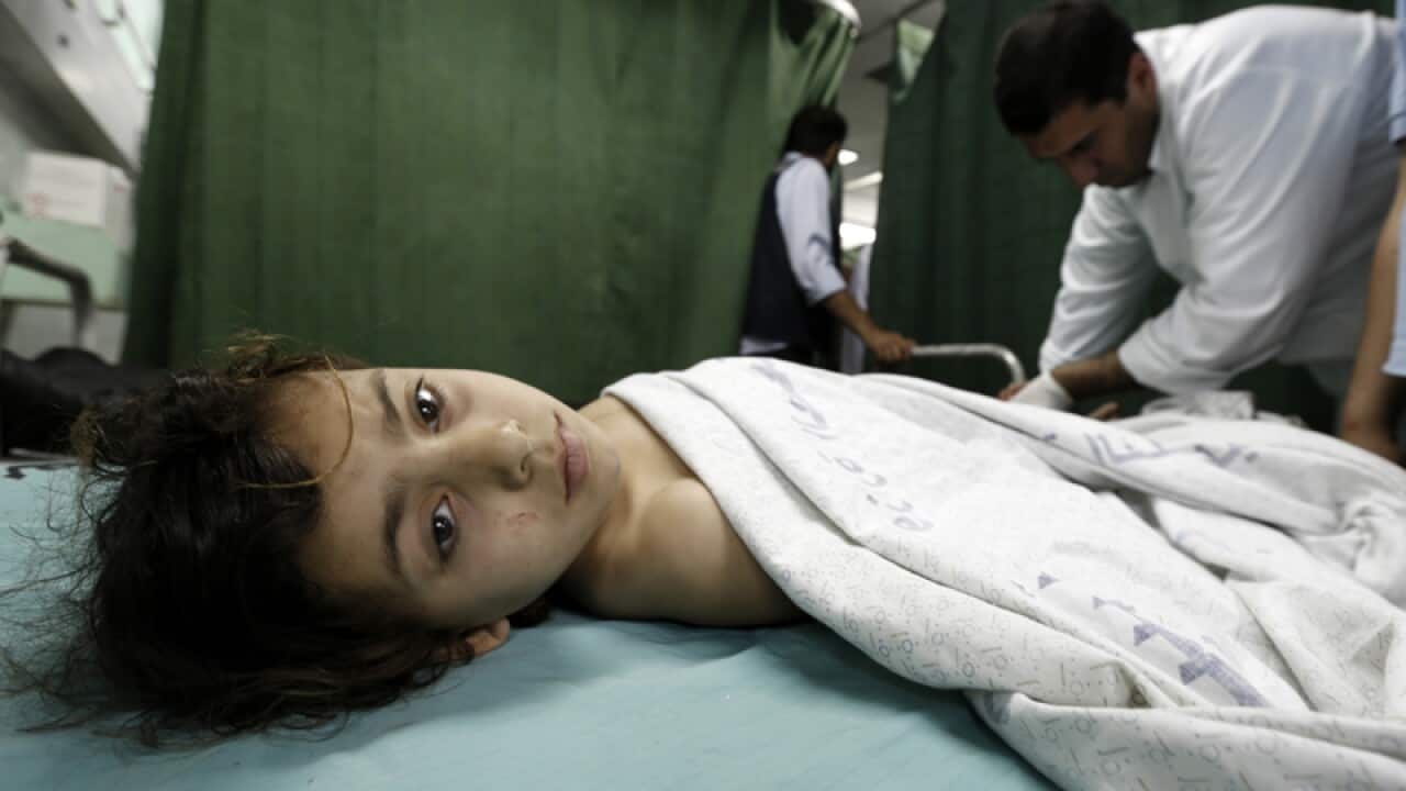 Palestinian doctors treat a wounded child following an air strike