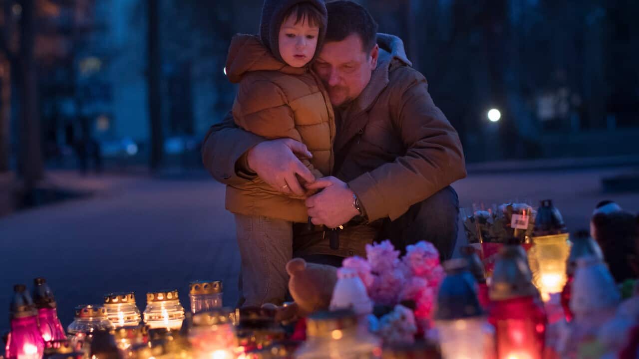 People light candles to commemorate the victims of Sunday's fire in a shopping mall in the Siberian city of Kemerovo,