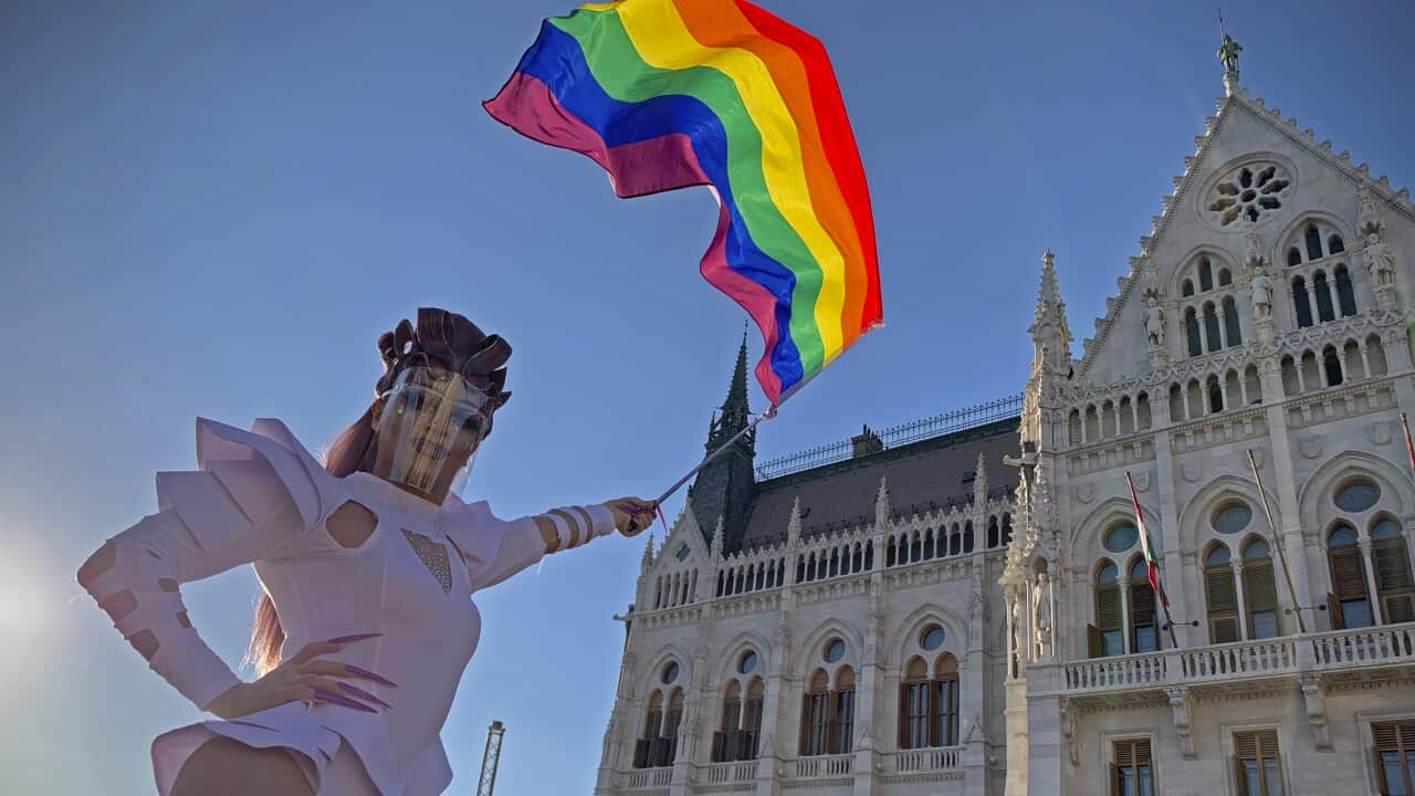 A drag queen waves a rainbow flag during an LGBTIQ+ rights demonstration in front of the Hungarian Parliament building in Budapest