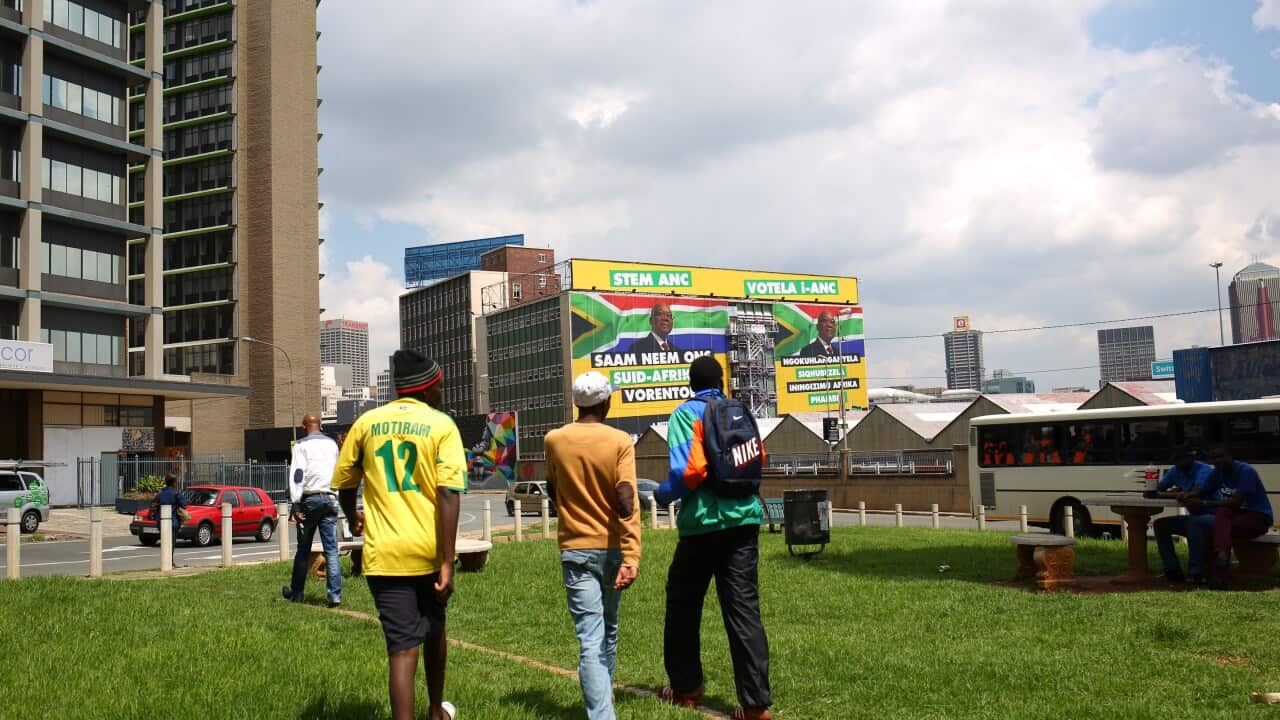 Young people in Johannesburg approach a billboard calling on the people of South Africa to vote for the ANC in the upcoming election Getty.jpg
