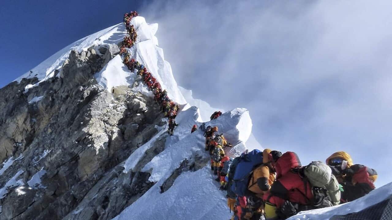 A queue of climbers on the top of Mount Everest's summit.