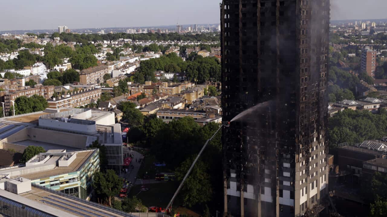 Firefighters work at the scene of a deadly blaze in west London