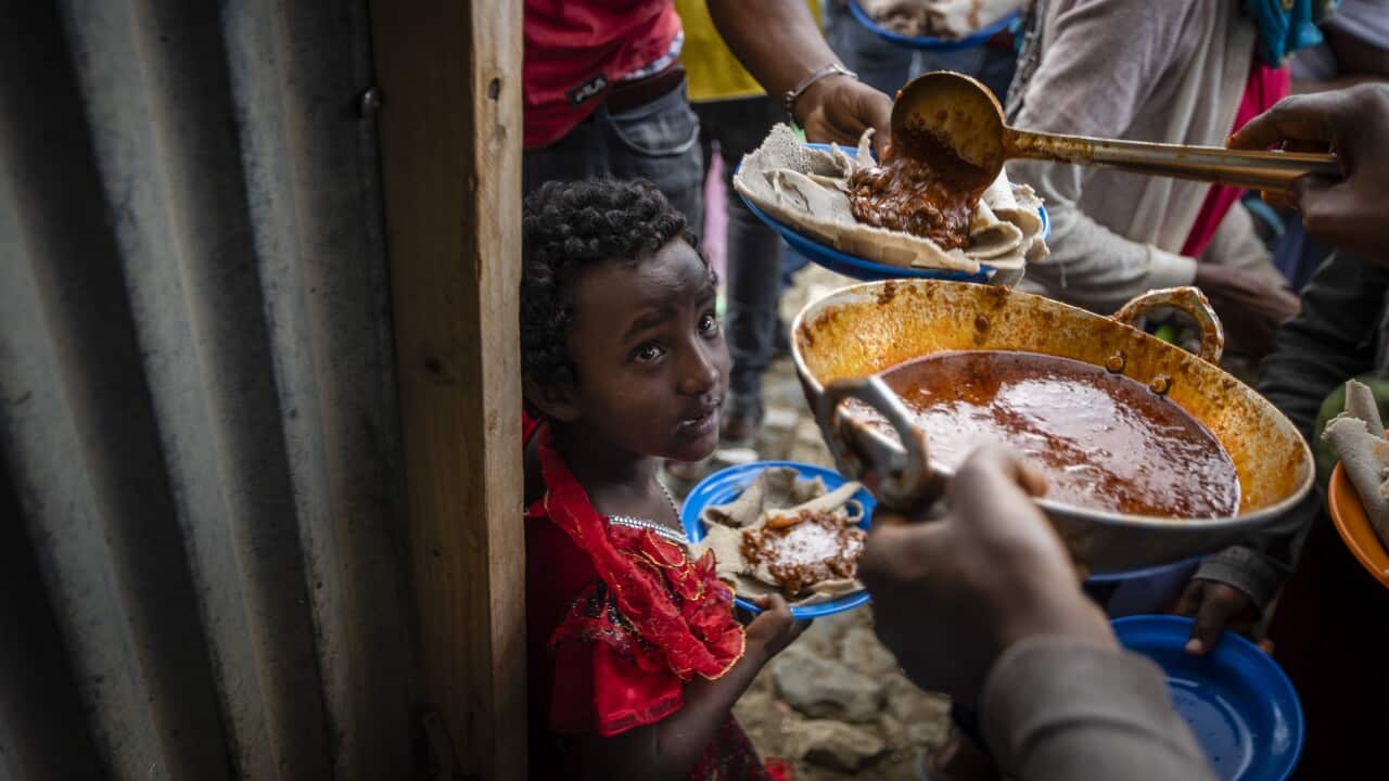 People receive food donated by local residents at a reception centre for the internally displaced in Mekele, in the Tigray region of northern Ethiopia