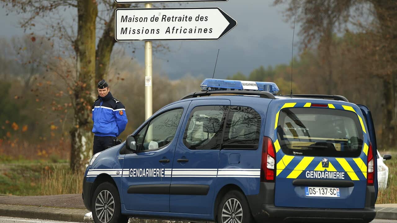 Police stand guard along a security area near the retirement home for Catholic missionaires in Montferrier-sur-Lez, near Montpellier
