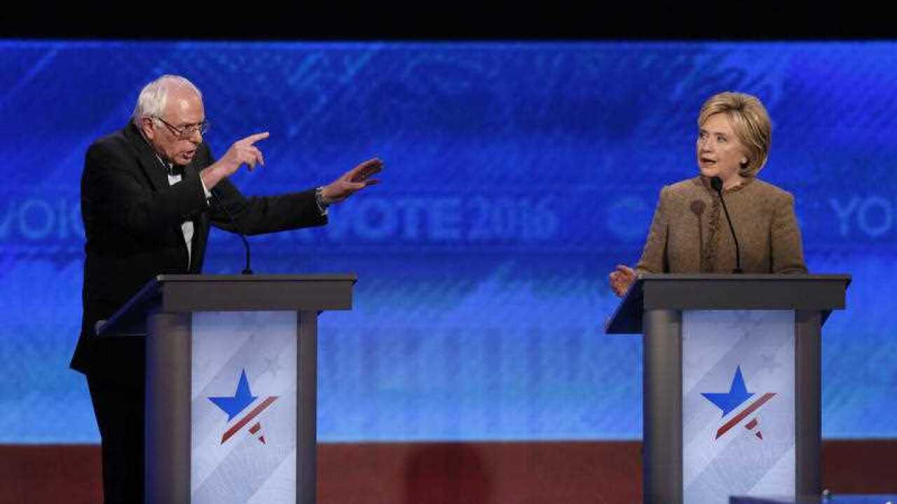 Bernie Sanders and Hillary Clinton speak during an exchange during the Democratic presidential primary debate