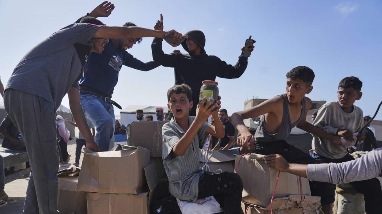 Palestinesi tra scatole di aiuti umanitari gestiti dall'agenzia americana Gaza Humanitarian Foundation.