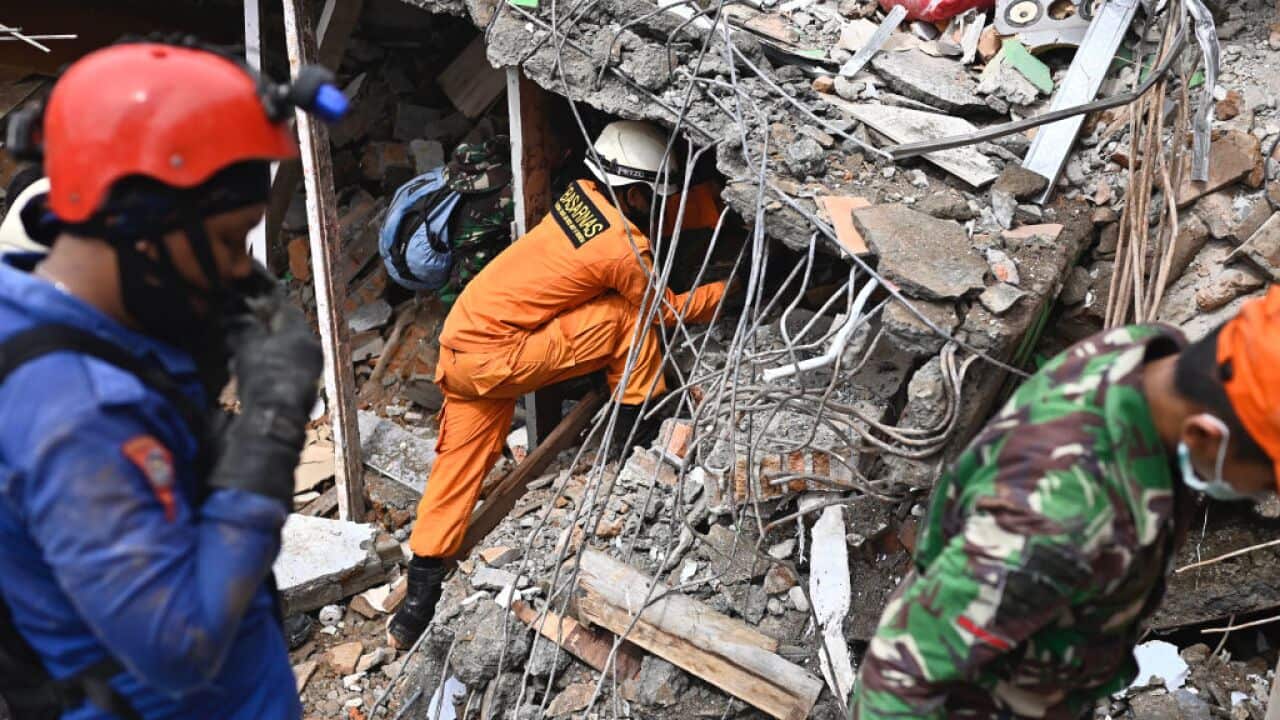 Rescuers search for survivors at a collapsed building in Mamuju city on January, a day after a 6.2-magnitude earthquake rocked Indonesia's Sulawesi island.