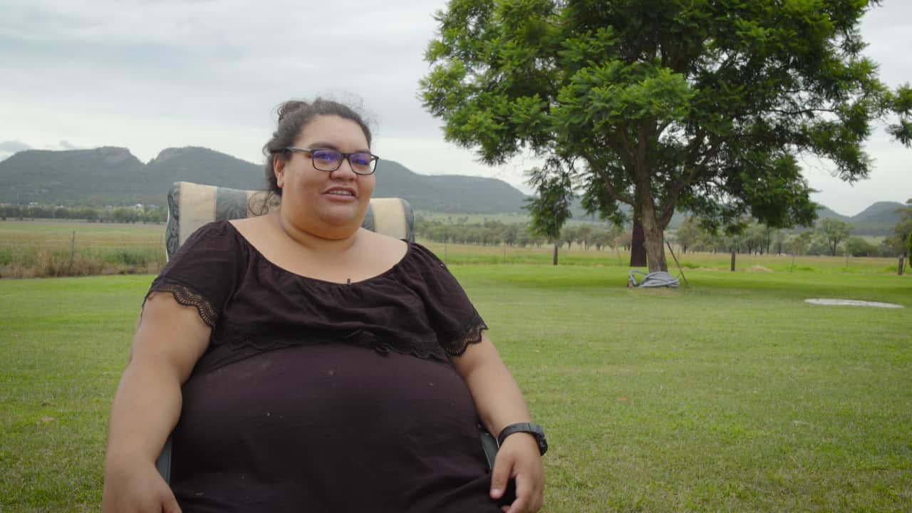 Honey Tawhai sits on her lawn.png