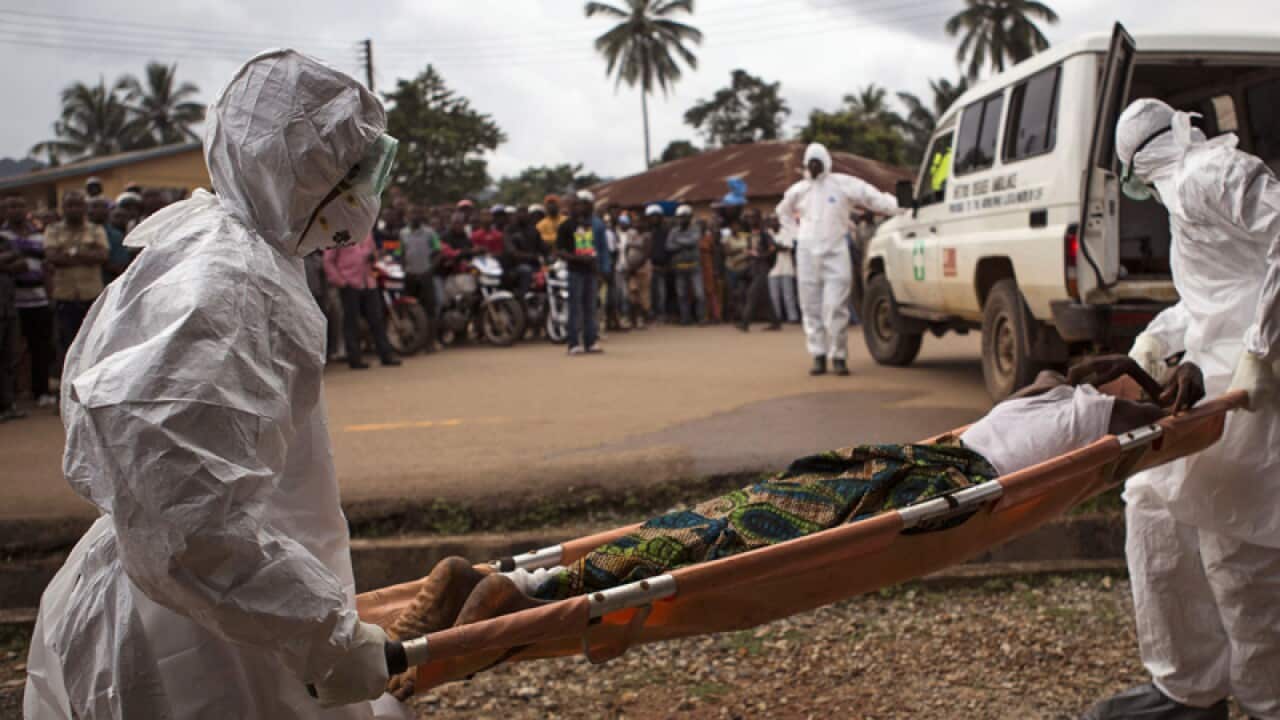 healthcare workers load a man suffering from the Ebola virus