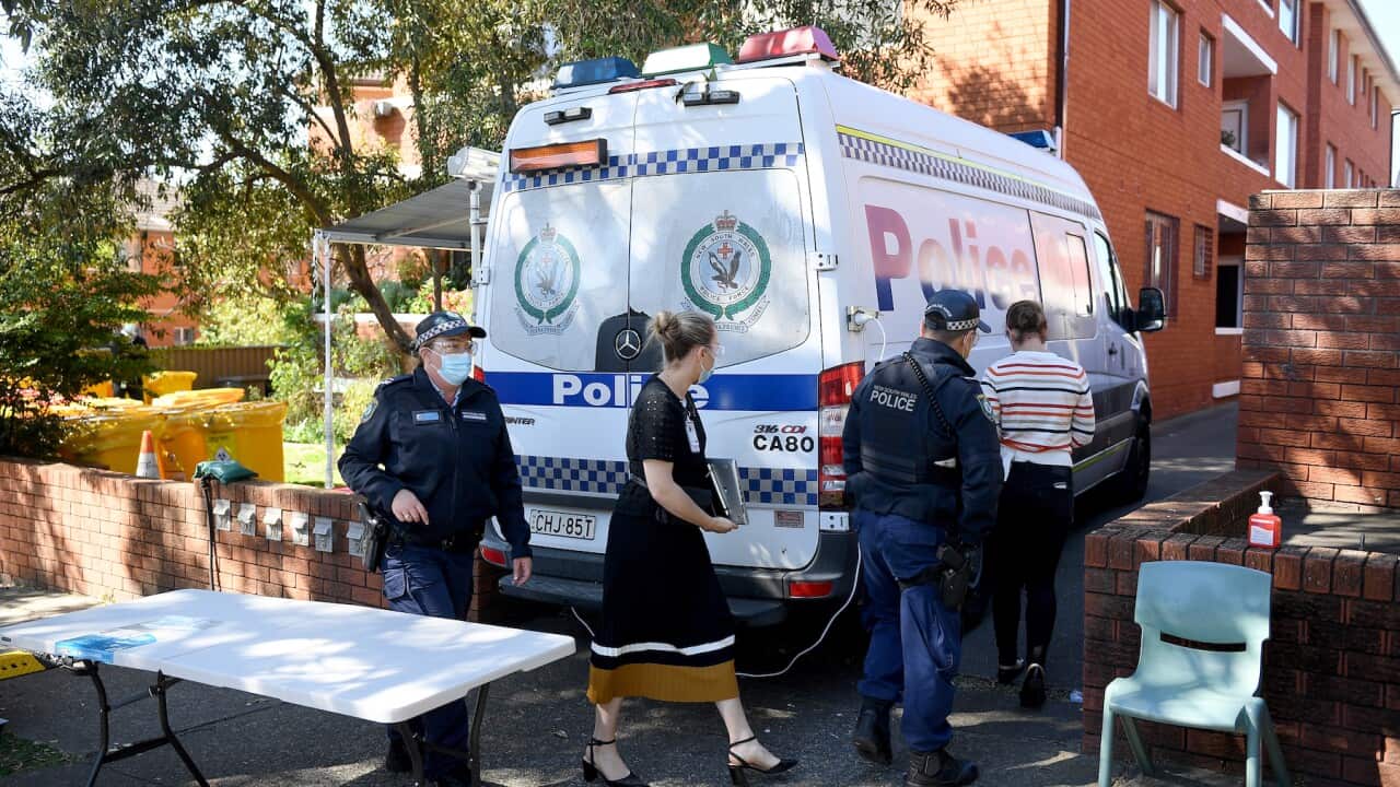 Health workers and Police officers are seen at a unit block under lockdown, in Campsie, south west of Sydney, Friday, August 20, 2021. (AAP Image/Dan Himbrechts) NO ARCHIVING
