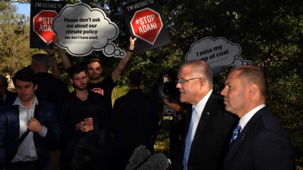 Prime Minister Scott Morrison Treasurer and Josh Frydenberg with anti-Adani protesters at a press conference in Melbourne.