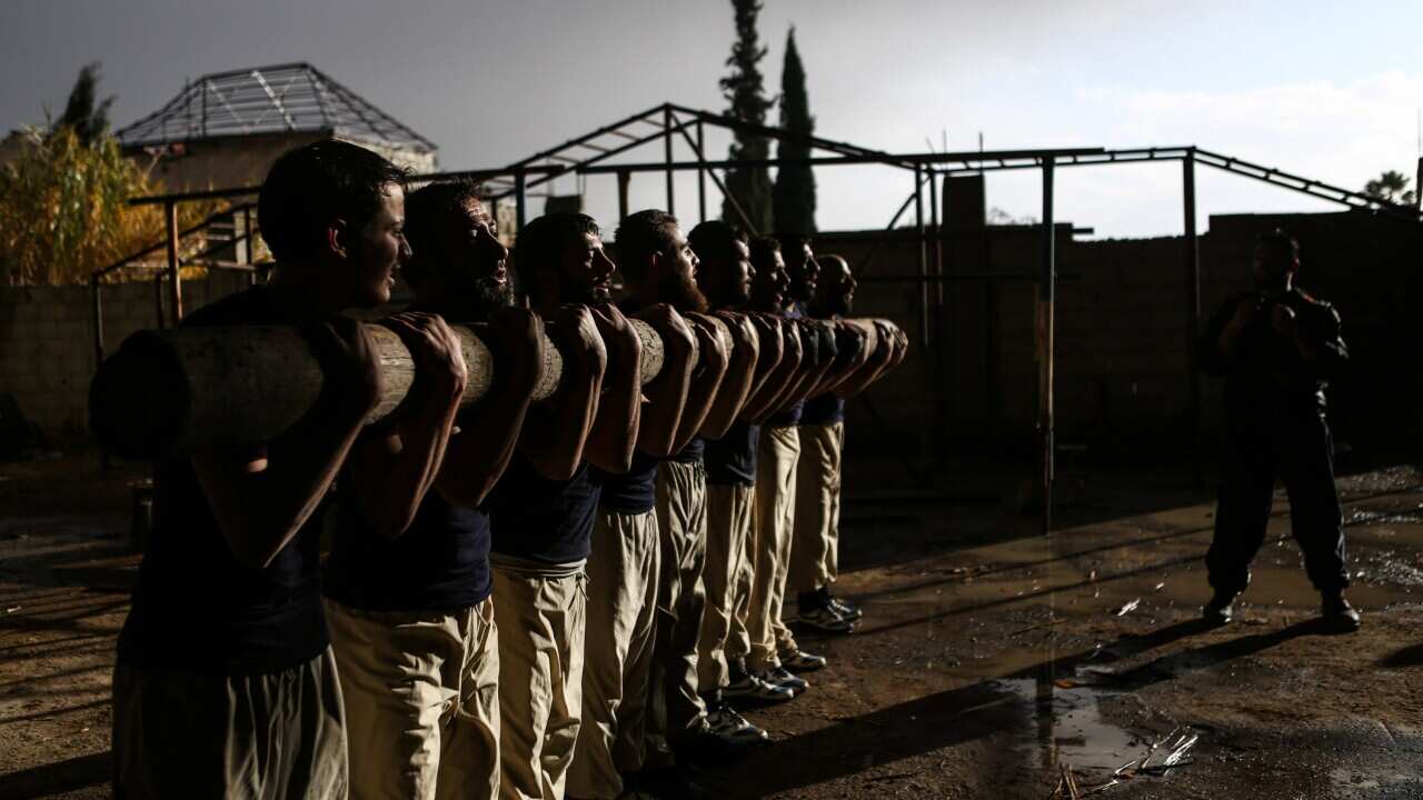 Cadets carry a wood log as part of their fitness training in Jaysh al-Islam Military Academy, in an undisclosed location, rebel-held Eastern Ghouta