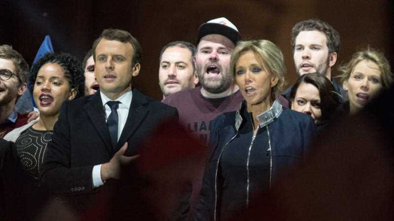Leader of 'En Marche !' Emmanuel Macron and wife Brigitte Trogneux sing the national anthem in front of supporters