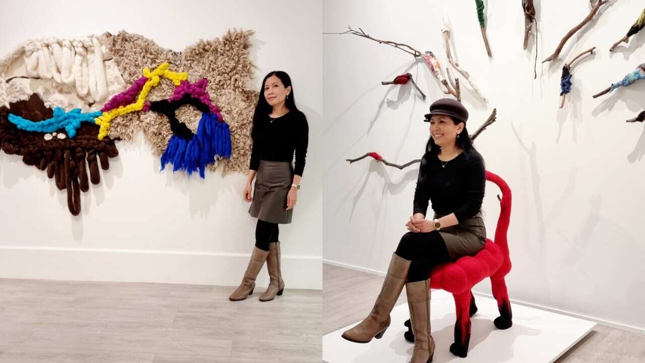 Artist Ririn Indah Puspita Yaxley posing with her art works at her solo exhibition Merangkul at Murray Art Museum Albury, 20 Jul to 15 Oct 2023. (Supplied).