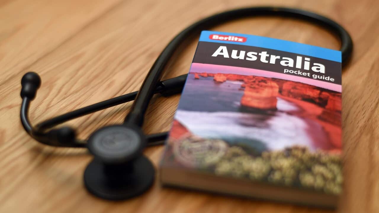 A doctor's stethoscope next to a guide book to Australia