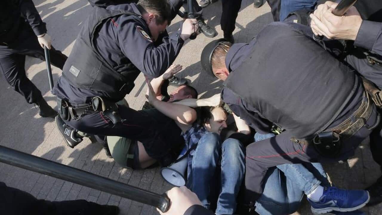 Russian police arrest a protester at a rally