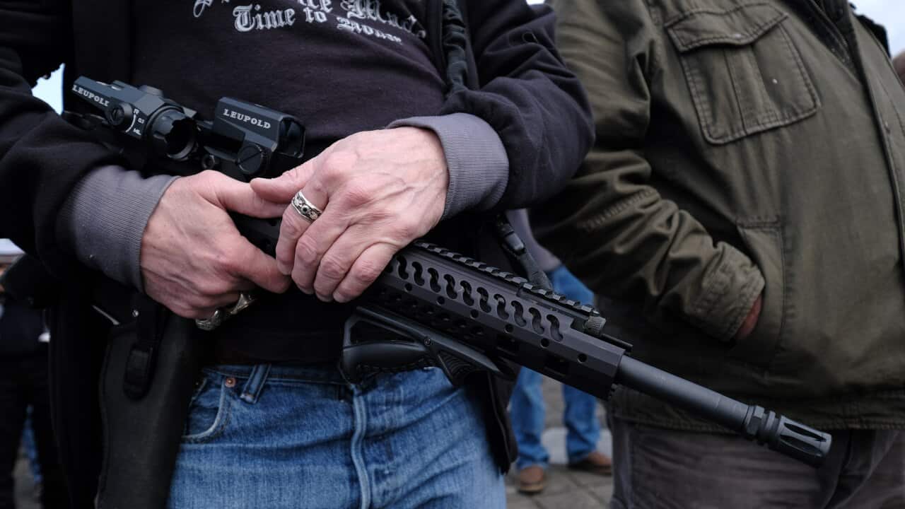 A man holds an AR-15 rifle, a popular choice among both gun hobbyists in the US and mass shooters.