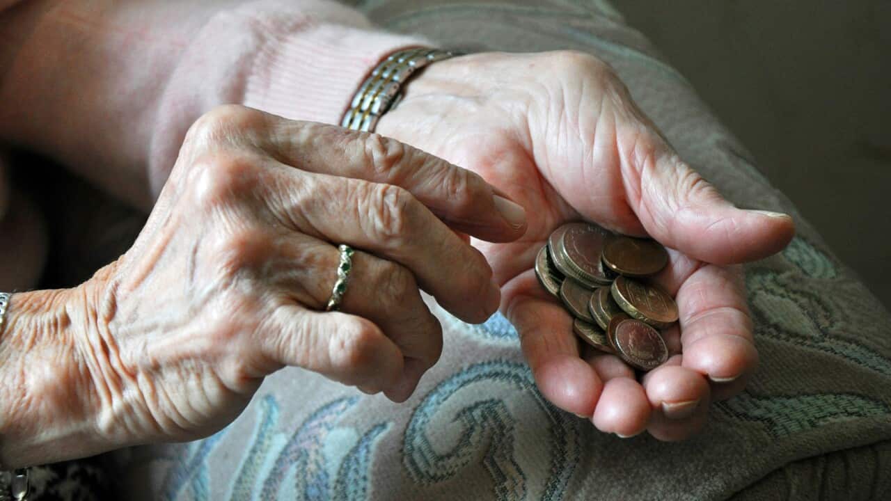 An elderly woman counting loose change.