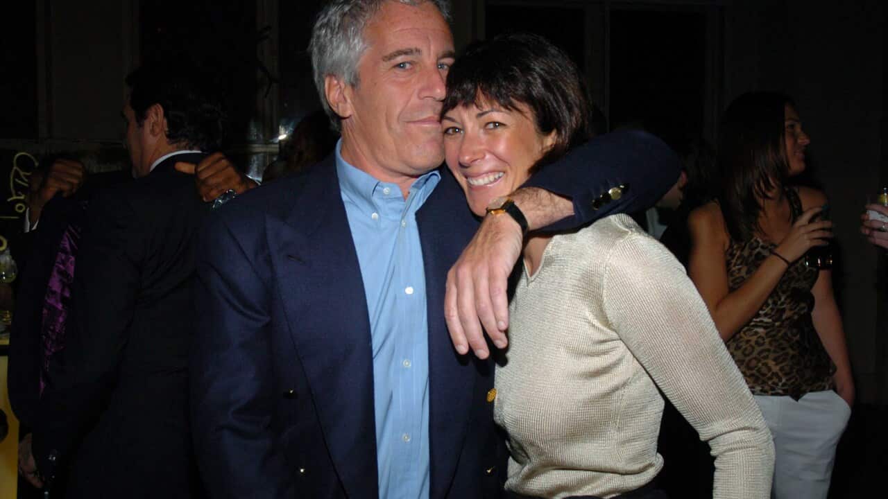 An older white man with grey hair, his arm around a middle-aged white woman who is smiling