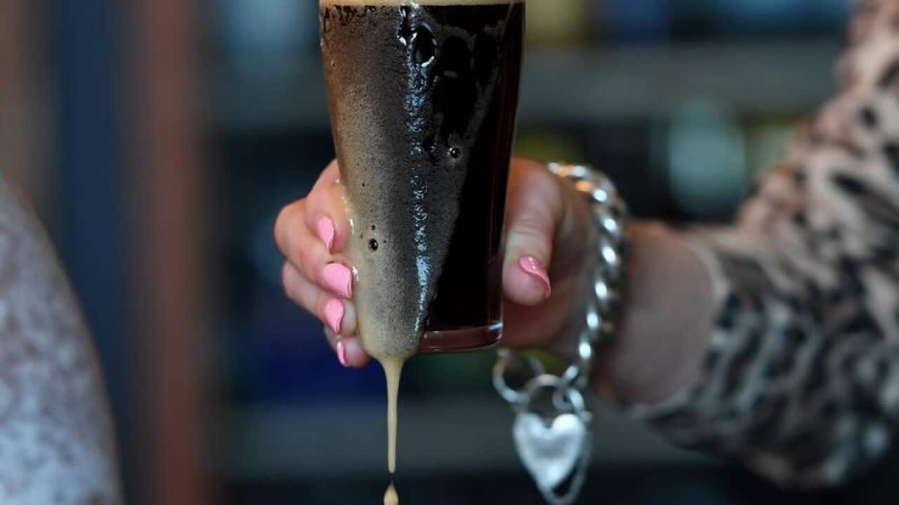 A barmaid pours a dark ale in Melbourne.