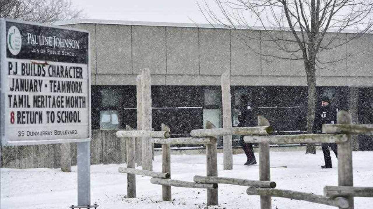 Police officers walk around Pauline Johnson Junior Public School in Toronto on Monday, Jan. 15, 2018.