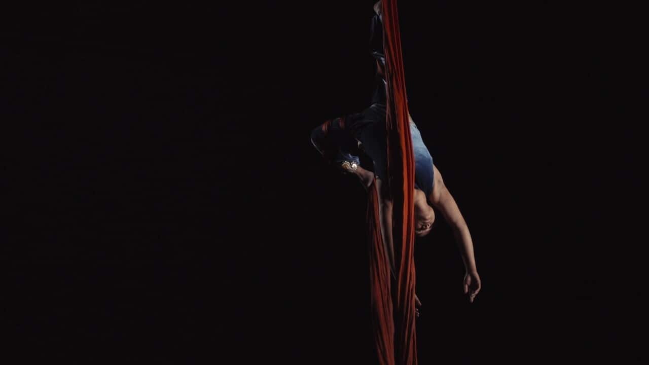 A woman performs a silks routine at the circus.