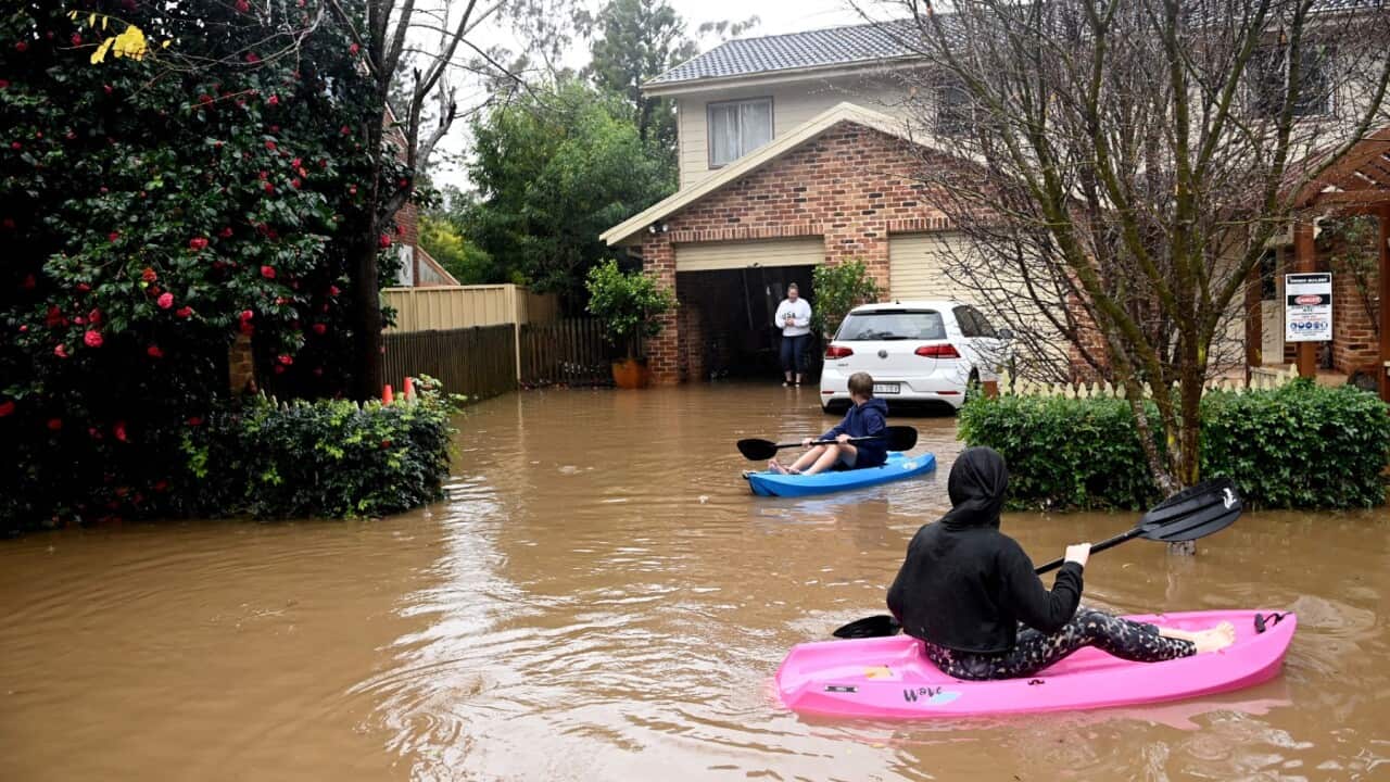 Children are seen on kayaks in floodwaters which have inundated the NSW town of Yarramalong on the Central Coast, north of Sydney,Tuesday, July 5, 2022.