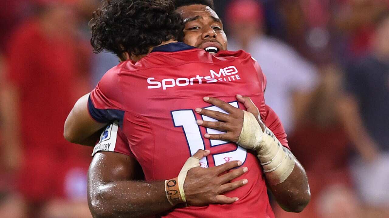 Reds player Karmichael Hunt (left) celebrates