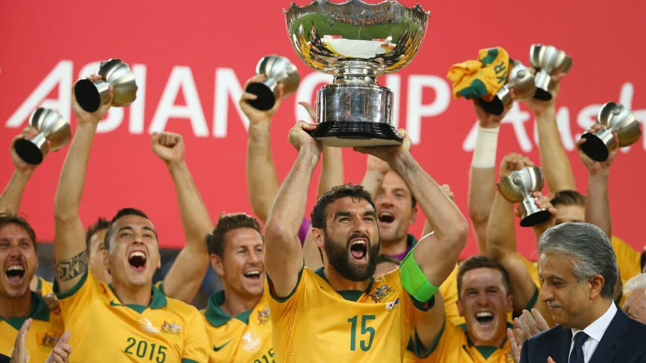 Socceroos skipper Mile Jedinak holds the AFC Asian Cup aloft as Australia celebrates beating Korea Republic (Getty)