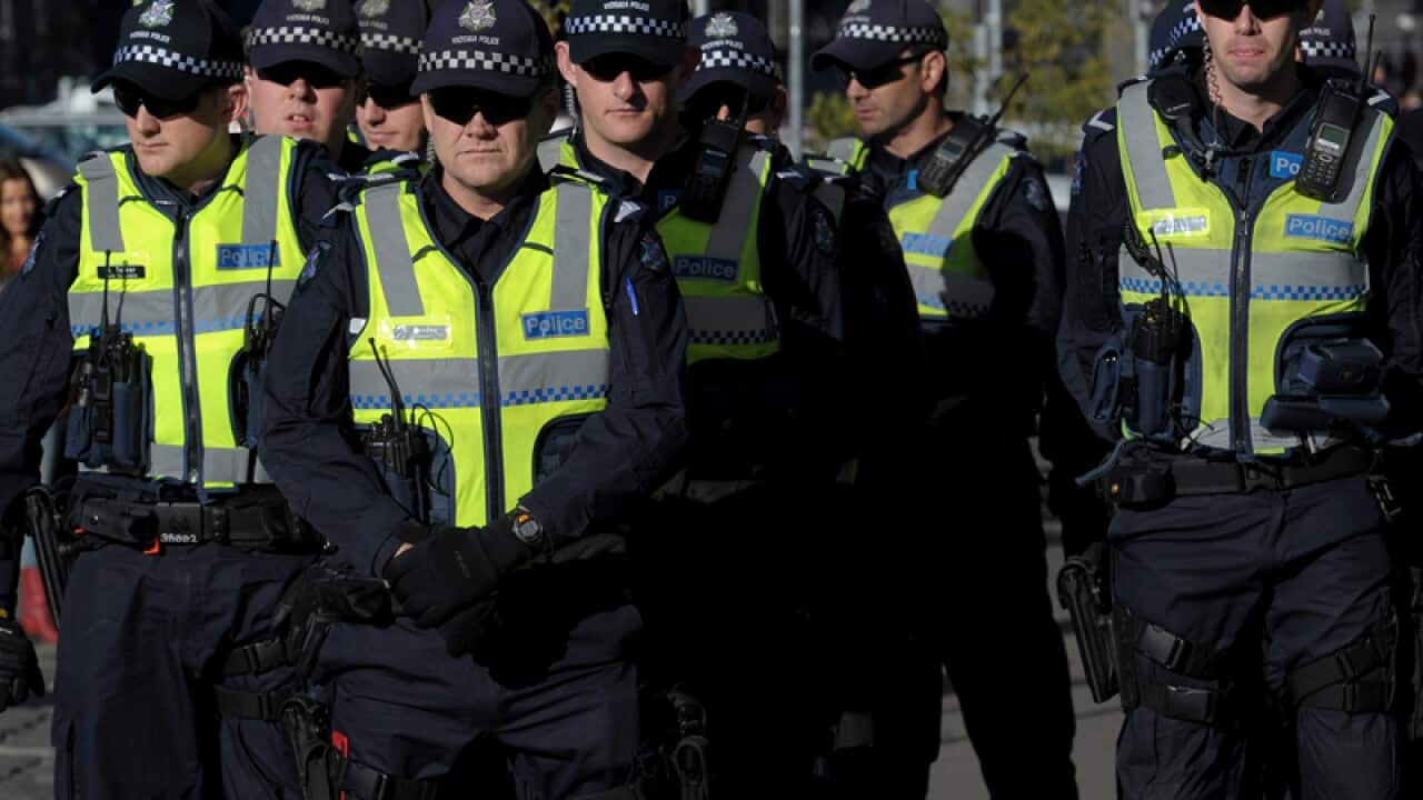 Police stand and watch protesters at Melbourne University
