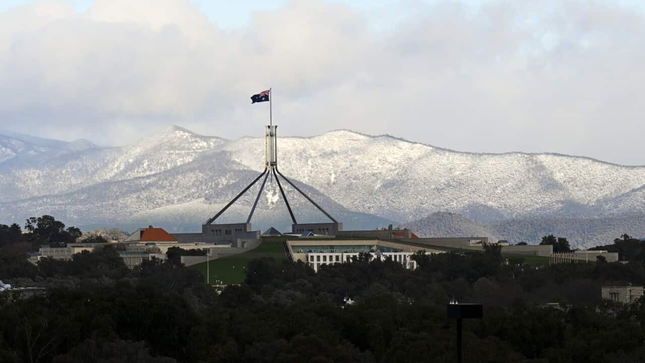 Snow-covered hills seen behind Parliament House in Canberra.