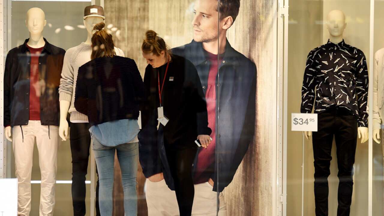 Window dressers adjust mannequins