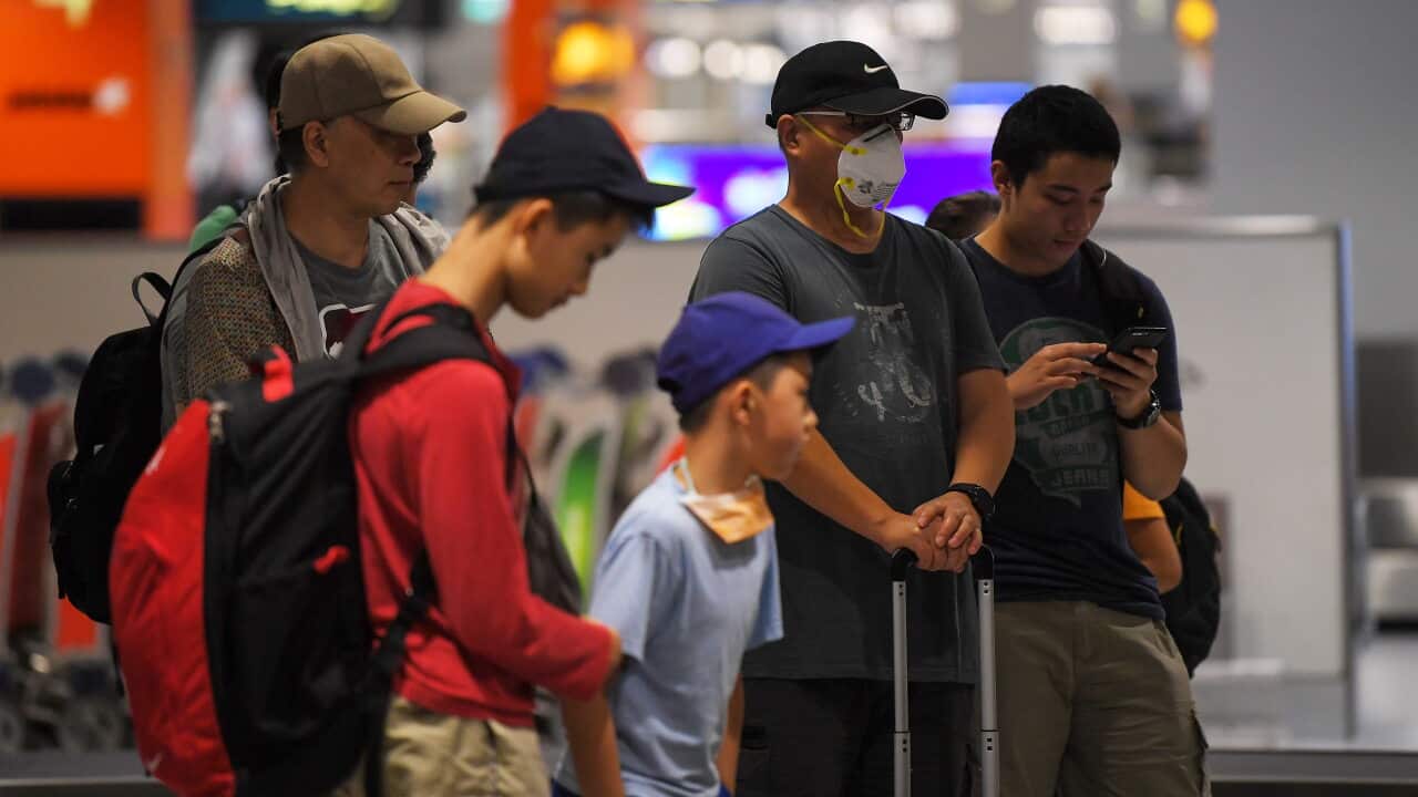 Travellers wait for their bags at Sydney airport