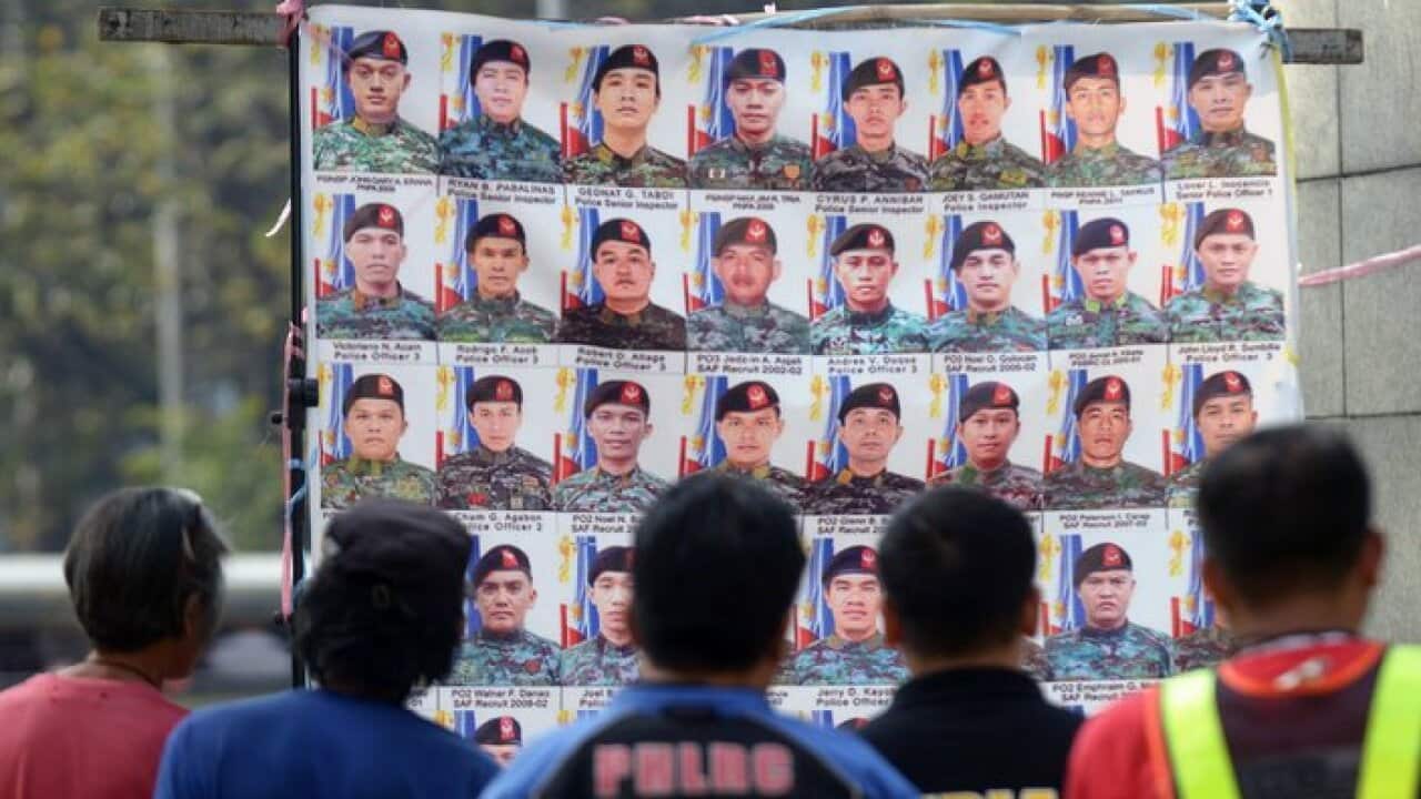 People look at a display of photos in Manila on February 7, 2015