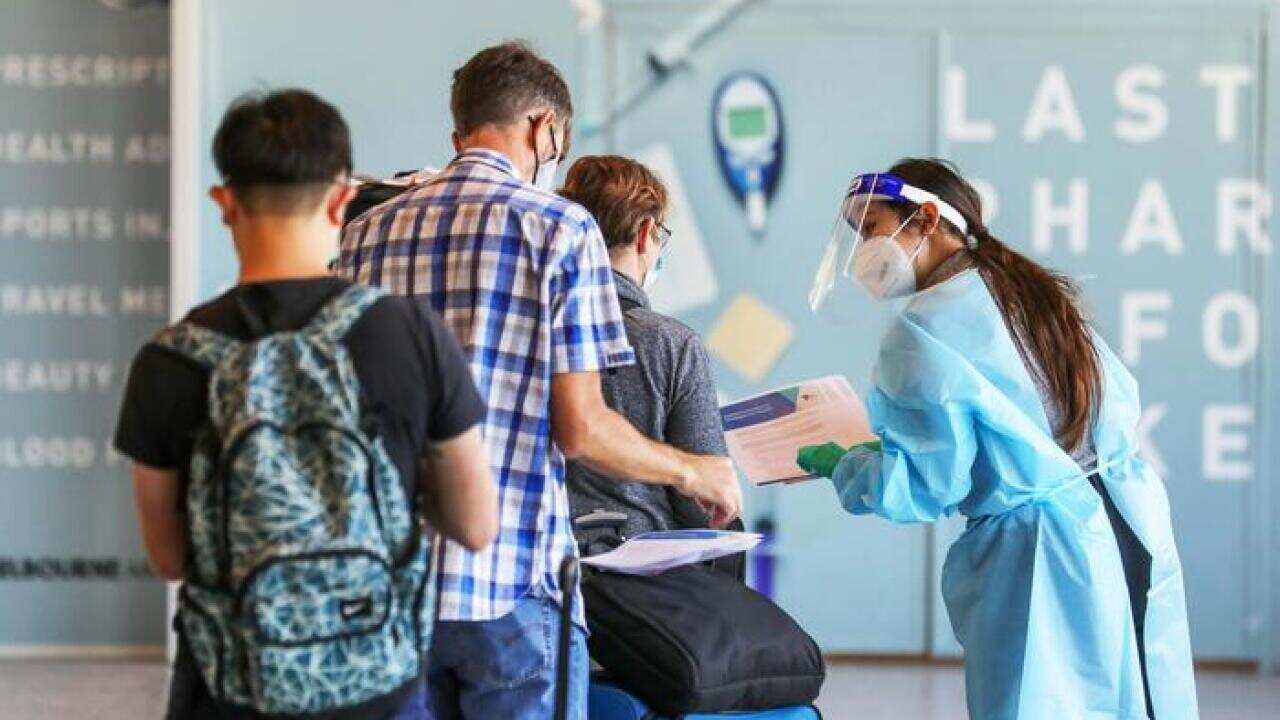 پرستاری در حال آزمایش مسافران سیدنی در میدان هوایی ملبورن