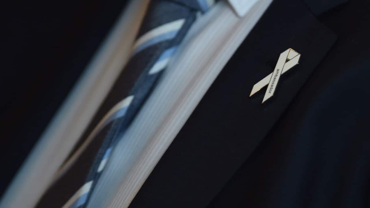 A White Ribbon pin worn at a White Ribbon day breakfast event.