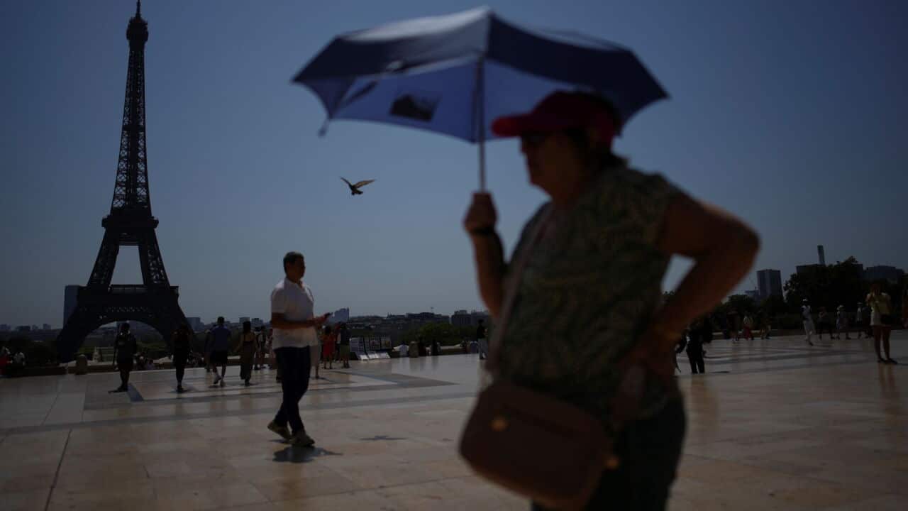 FILE - People walk at Trocadero plaza near the Eiffel Tower during a heat wave July 2, 2025, in Paris. (AP Photo-Christophe Ena, File).jpg