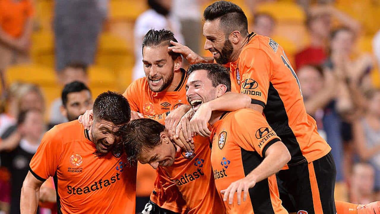 Roar players swamp Holman after scoring the winner