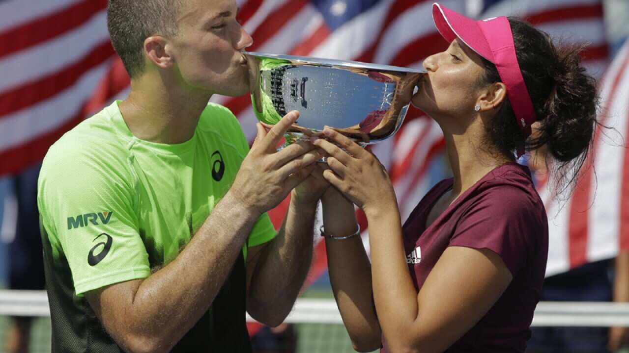 Bruno Soares and Sania Mirza kiss the championship trophy