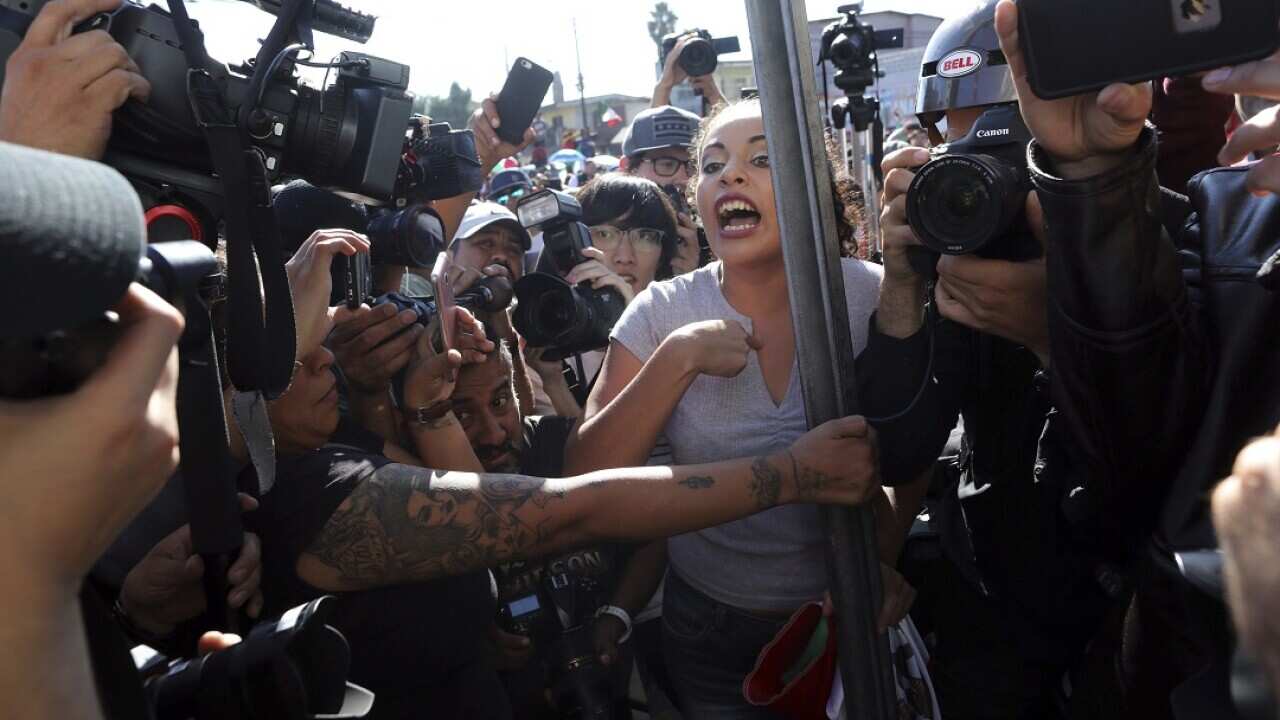 An anti-migrant demonstrator is surrounded by the press during a protest against the presence of thousands of Central American migrants in Tijuana.