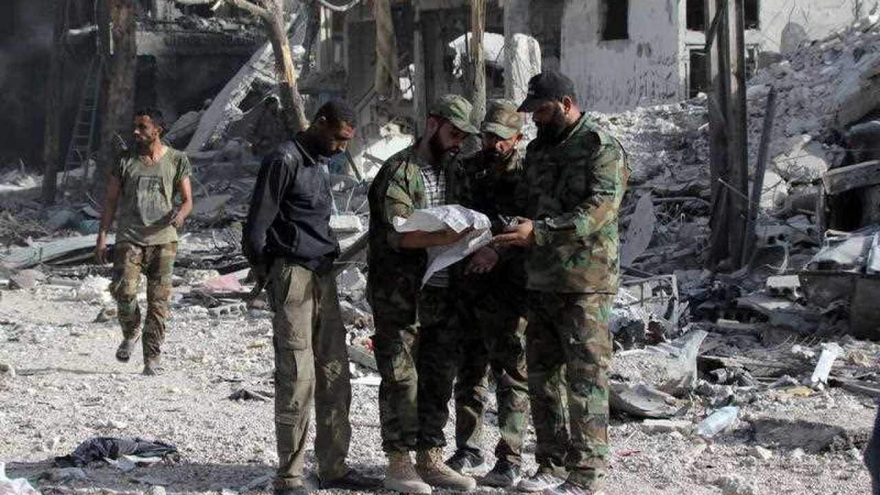 Syrian soldiers look at a map in al-Hajar al-Aswad neighborhood in south Damascus, Syria, 21 May 2018. According to reports, the Syrian army claims it has regained full control over Damascus' surrounding areas.