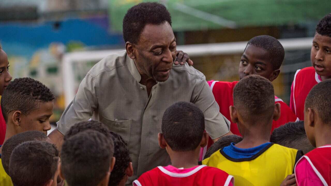 Legendary Brazilian former football player Pele speaks with children during the inauguration ceremony of the new technology football pitch installed at Mineira favela in Rio de Janeiro (Getty)