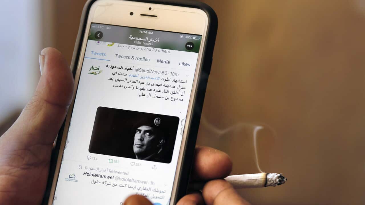 A man reads Saudi news on Twitter fronted by a picture of the prominent bodyguard to Saudi Arabia's King Salman Maj. Gen. Abdulaziz al-Fagham.