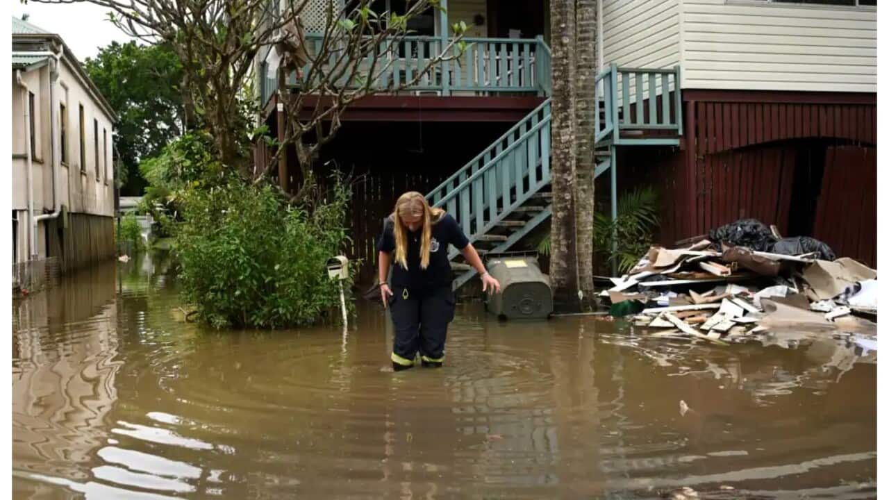 อาสาสมัครบริการดับเพลิงในชนบทตรวจสอบบ้านที่ล้อมรอบด้วยน้ำท่วมเมื่อวันที่ 31 มีนาคม 2022 ในเมืองลิสมอร์ รัฐนิวเซาท์เวลส์